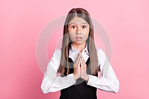 Photo of young school girl unhappy ask beg hands together pleading isolated over pink color background