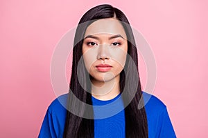 Photo of young serious asian woman wear blue t-shirt casual clothes isolated on pastel pink color background