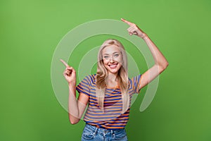 Photo of young smile happy girl directing fingers up empty space new apple company presentation isolated on green color