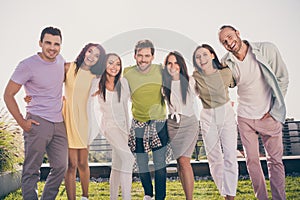 Photo of young smiling cheerful positive good mood happy group of people hug each other having fun outside on rooftop