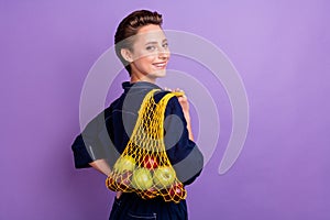 Photo of young smiling good-looking pretty girl earth activist use mesh bag for shopping isolated on purple color