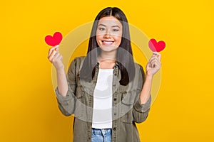 Photo of young smiling vietnamese girl wear khaki trendy shirt brunette hair hold red love symbols valentine day