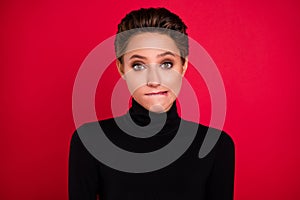 Photo of young unhappy doubtful uncertain woman bite lips teeth nervous isolated on red color background