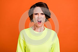 Photo of young unhappy sad displeased angry woman bad mood grimace isolated on orange color background