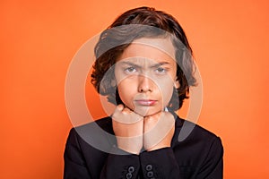 Photo of young unhappy upset sad boy hold hands chin face offended bad mood  on orange color background