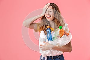 Photo of young unhappy woman holding plastic waste and crying