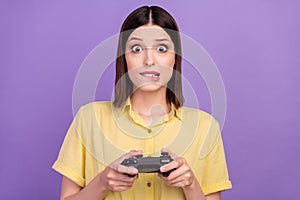 Photo of young woman afraid bite lips teeth play game station race speed lose isolated over violet color background