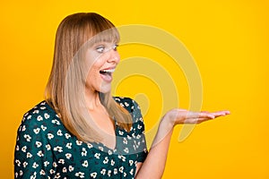 Photo of young woman excited surprised sale demonstrate product ad offer look empty space isolated over yellow color