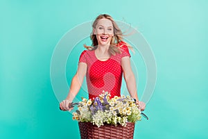 Photo of young woman happy positive smile travel bicycle bunch of wildflowers isolated over turquoise color background
