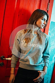 Photo of young woman looking to side against background of doors indoors