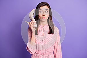 Photo of young woman pouted lips send air kiss look empty space hold stilletos like phone isolated over purple color