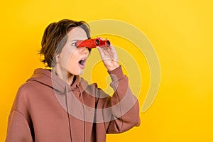 Photo of young woman staring watching binoculars looking empty space her house broken nature disaster isolated on yellow