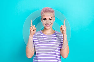 Photo of young woman wear striped t shirt indicate fingers up above head useful information beauty tips isolated on blue