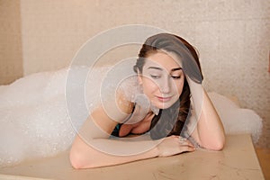 photo of a young woman in white foam relaxing in a hamam