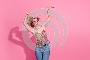 Photo of youth fancy crazy girl wearing denim jeans with stylish bright singlet dancing hands up rhythm  on pink