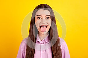 Photo of youth funky girl have fun show tongue rude childish humorous isolated over yellow color background