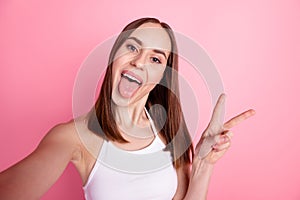 Photo of youth lovely girl have fun stick-out shoot selfie show peace cool v-symbol isolated over pink color background