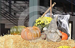 Photo zone near a cafe, shop, house for Halloween. Pumpkins, hay, flowers, lantern