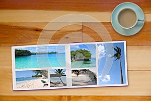 Photobook Album on Wooden Floor Table with Travel Photos and Coffee or Tea in Cup