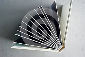 Photobook in hard leather cover on a gray concrete background. Making photos and storing them.A wedding album or book in