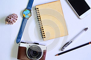 Photocamera and notebook flat lay on white background. Summer travel banner template.