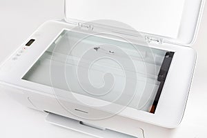 Photocopier with open lid, glass area surface visible. Small home use scanner, copier, modern white printer tool top view closeup