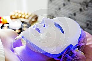 Photodynamic therapy facial mask on woman`s face. photo
