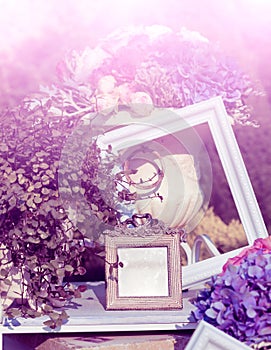 Photoframes and vase with flowers in the garden