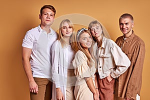 Photogenic group of young people posing in stylish cozy outfit, studio shoot