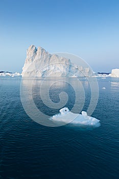 Photogenic and intricate iceberg under an interesting and blue sky during sunset. Effect of global warming in nature.