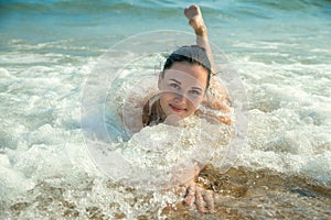 Photograph of a beautiful model relaxing on a beach in the waves