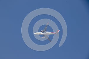 Photograph of a big white flying airplane in the sky