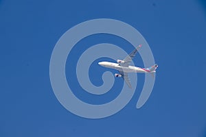 Photograph of a big white flying airplane in the sky