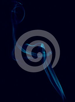 Photograph of blue smoke on a black background.