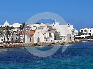 Photograph of a coastal village on the island of Menorca taken from a boat