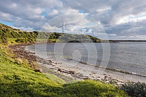 Photograph of Currie Lighthouse on a hill viewed from across the bay on King Island