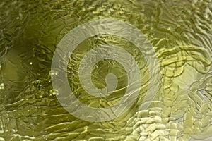 Photograph of the curved surface of yellow oil.