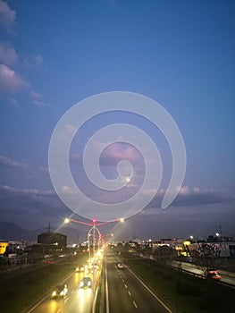 Photograph of a double-lane road at the end of the day when the sky is nuanced