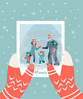 A photograph with a family in hand. Winter Christmas concept. Family photo on a background of snowflakes.