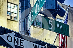 Photograph of the famous Fifth Avenue sign and the American flag, located in the heart of Manhattan, in the heart of the Big Apple