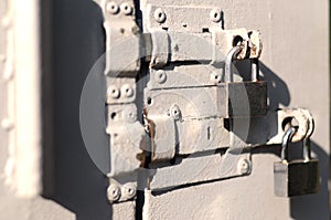 A photograph of the fragment is a metal door with two square padlocks. Selective focus with shallow depth of fiel