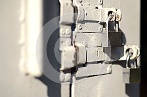 A photograph of the fragment is a metal door with two square padlocks. Selective focus with shallow depth of fiel