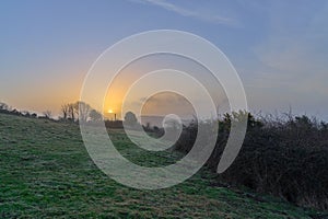 A photograph of a hazy sunrise as seen from Brading Downs on the Isle of Wight