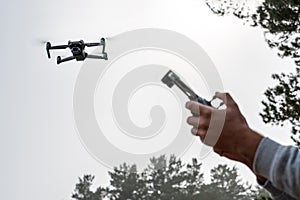 Photograph of man& x27;s hands holding the remote control of a Drone, Drone Operator . Technology concept. man is having