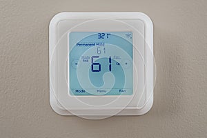 Photograph of a modern thermostat for heating and cooling