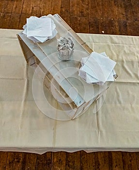 photograph of a nice tray created with a wooden vegetable box with beige placemat with a toothpick holder and napkins on it..