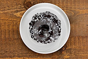Donut with biscuits on a white saucer with wooden background photo