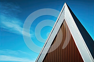 Photograph of the pointed gabled roof of a modern design of a house, in Nordic triangular style, with blue sky