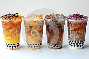 Photograph presenting four boba tea in plastic cups isolated on white background