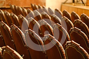 Photograph of the Rows of theatre seats. beige soft velvet chairs in the theater hall